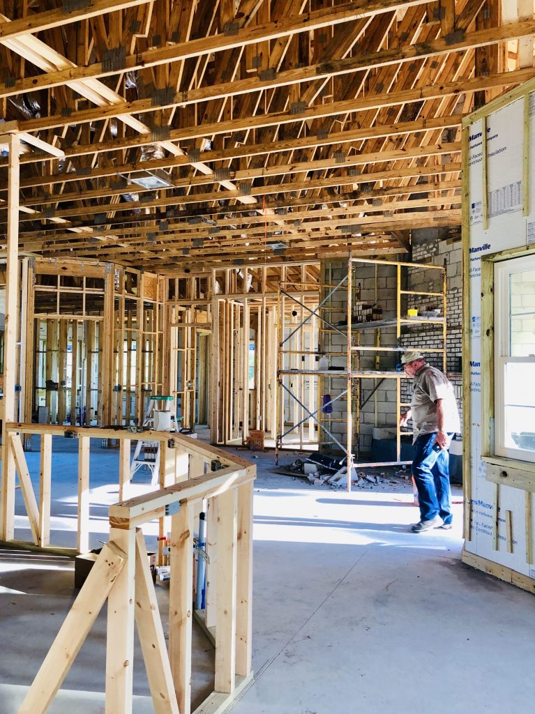 Interior de vivienda en construcción con estructura de madera y andamios